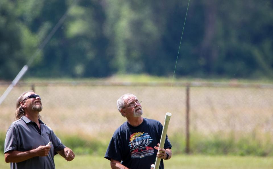 Two attendees use a projectile device to set up amateur radio equipment during the annual ham radio Field Day event at Vienna Park on June 25.