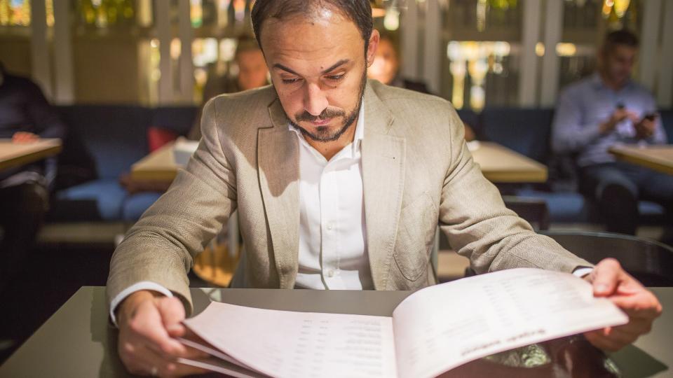 Man at the restaurant looking at the menu.