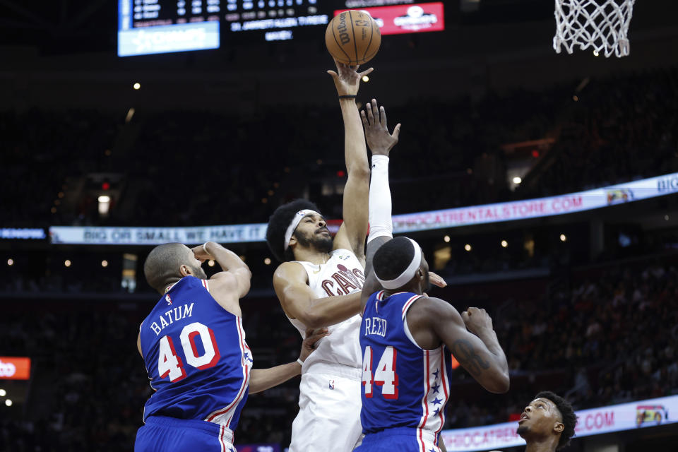 Cleveland Cavaliers center Jarrett Allen shoots against Philadelphia 76ers forward Paul Reed (44) and forward Nicolas Batum (40) during the second half of an NBA basketball game Friday, March 29, 2024, in Cleveland. (AP Photo/Ron Schwane)