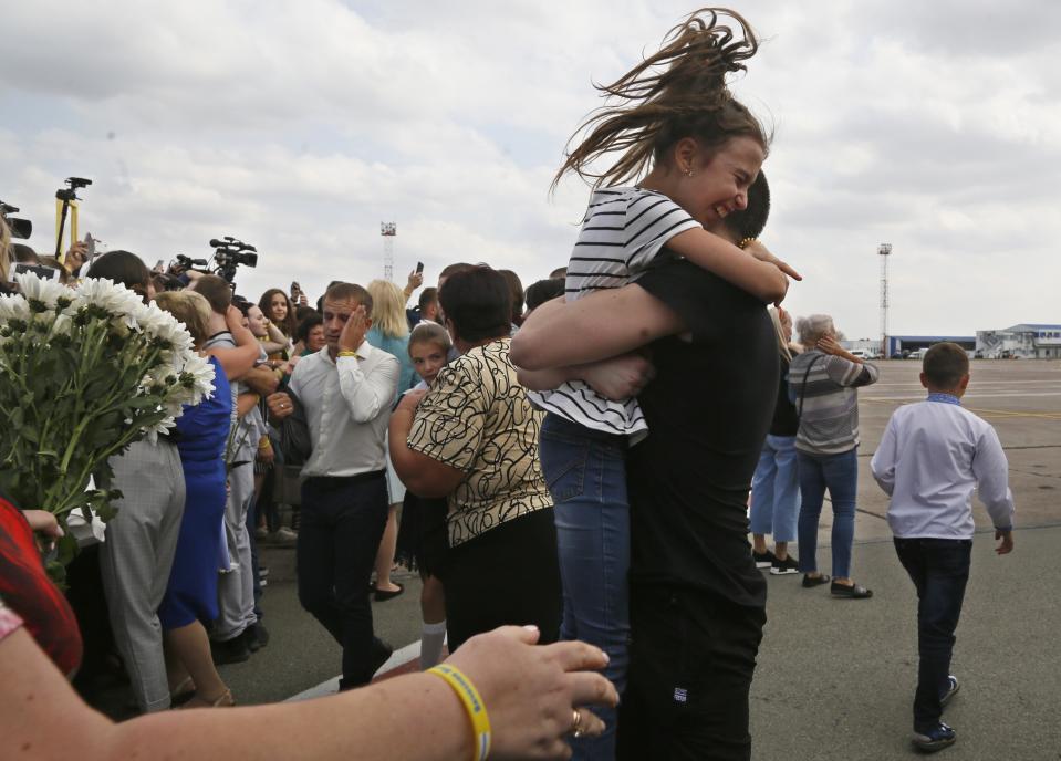 Relatives of Ukrainian prisoners freed by Russia greet them upon their arrival at Boryspil airport, outside Kyiv, Ukraine, Saturday, Sept. 7, 2019. Planes carrying prisoners freed by Russia and Ukraine have landed in the countries' capitals, in an exchange that could be a significant step toward improving relations between Moscow and Kyiv. The planes, each reportedly carrying 35 prisoners, landed almost simultaneously at Vnukovo airport in Moscow and at Kyiv's Boryspil airport. (AP Photo/Efrem Lukatsky)