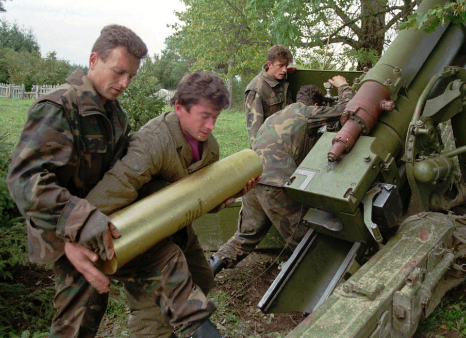 FILE - In this Oct. 4, 1995. file photo, Bosnian government soldiers load a 130mm howitzer with shells at their artillery position near the Serb-held town of Sanski Most, some 60 miles northwest of Sarajevo, Bosnia. While it brought an end to the fighting, the Dayton peace agreement baked in the ethnic divisions, establishing a complicated and fragmented state structure with two semi-autonomous entities, Serb-run Republika Srpska and a Federation shared by Bosniak and Croats, linked by weak joint institutions. (AP Photo/Darko Bandic, File)