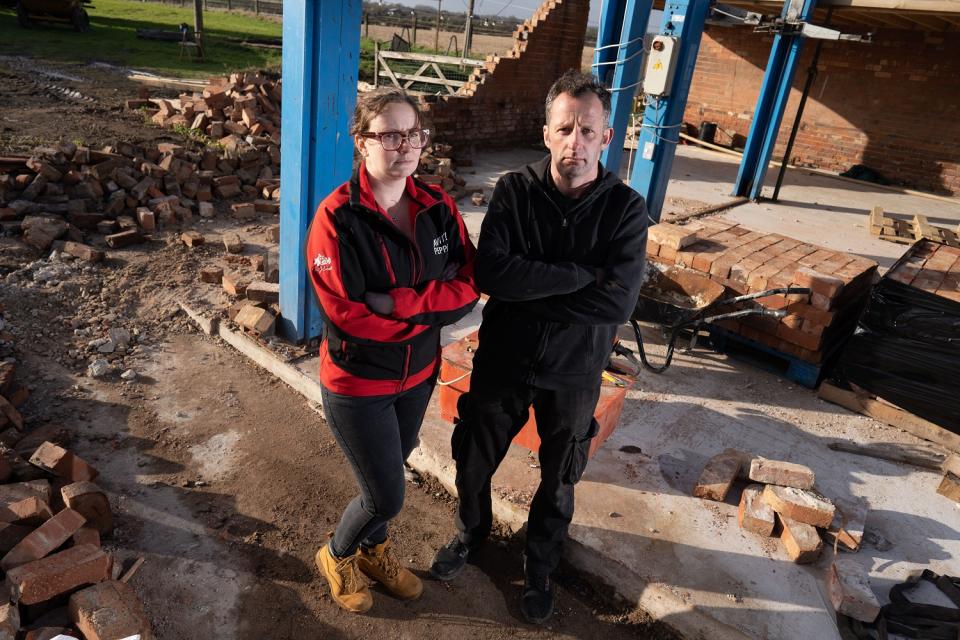 Ewen Sergison and partner Rachel Lovett of Dunham, Nottinghamshire in front of the wreckage where with their sports cars were destroyed by Storm Eunice (SWNS)