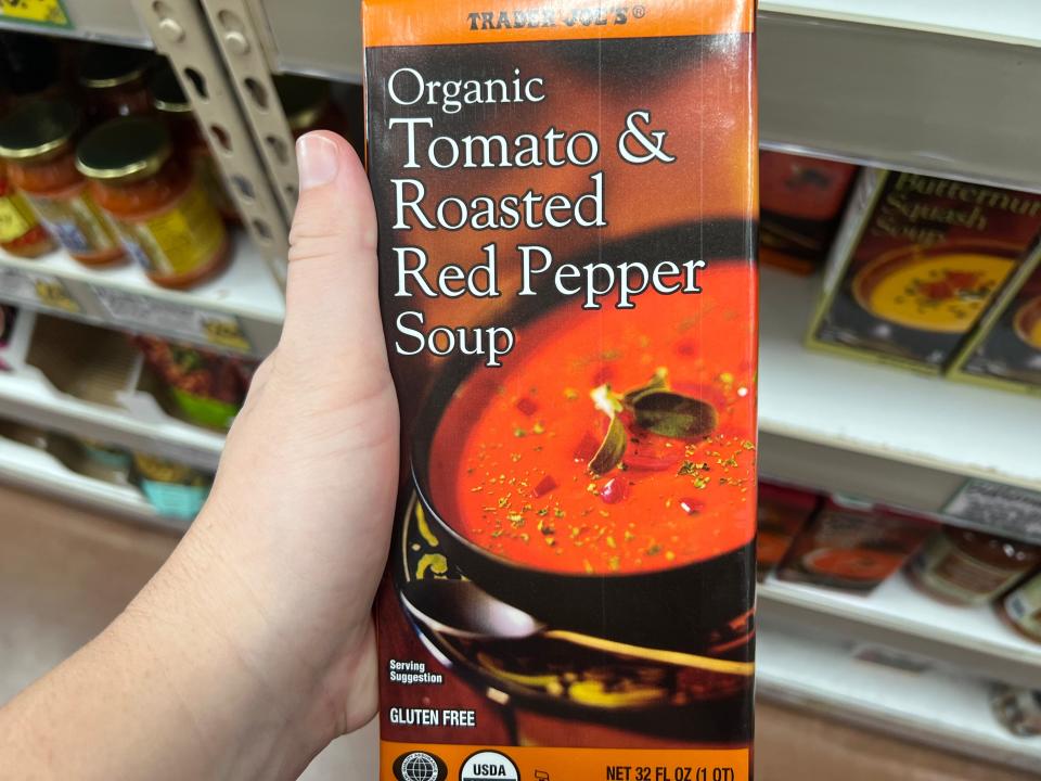 The writer holds a box of Trader Joe's organic tomato and roasted red pepper soup