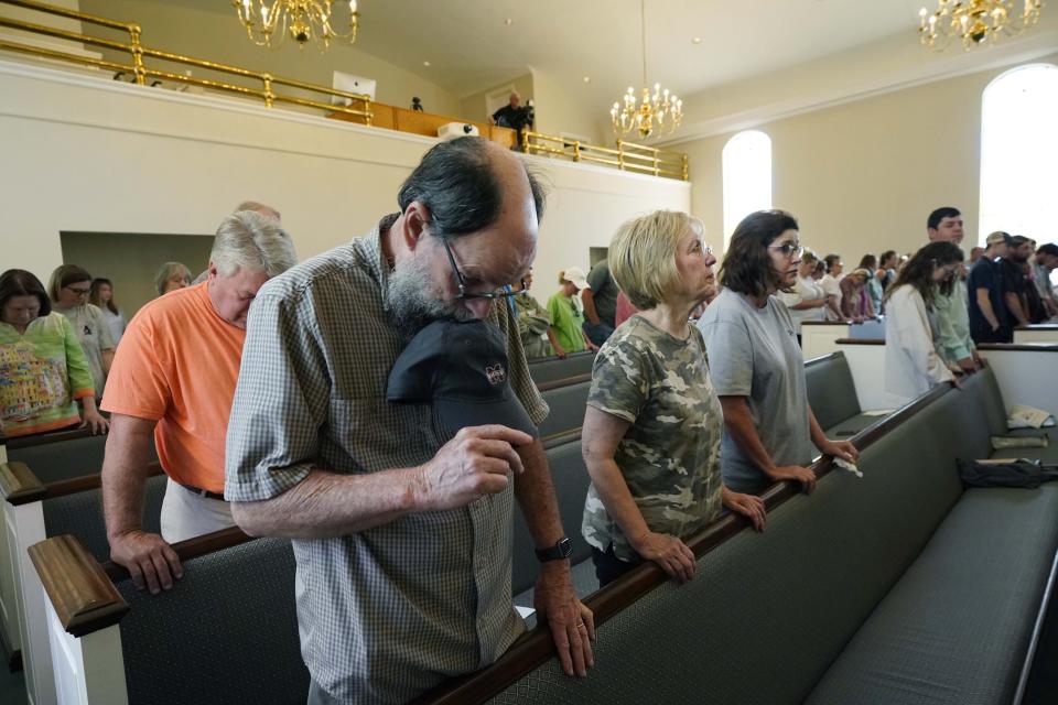Members bow their heads in prayer during a service at the First Baptist Church in Rolling Fork, Miss., Sunday, March 26, 2023. Pastor Britt Williamson addressed the congregation about the effects of the Friday evening tornado that hit their community, and how they needed to reach out to each other for support and assistance. (AP Photo/Rogelio V. Solis)
