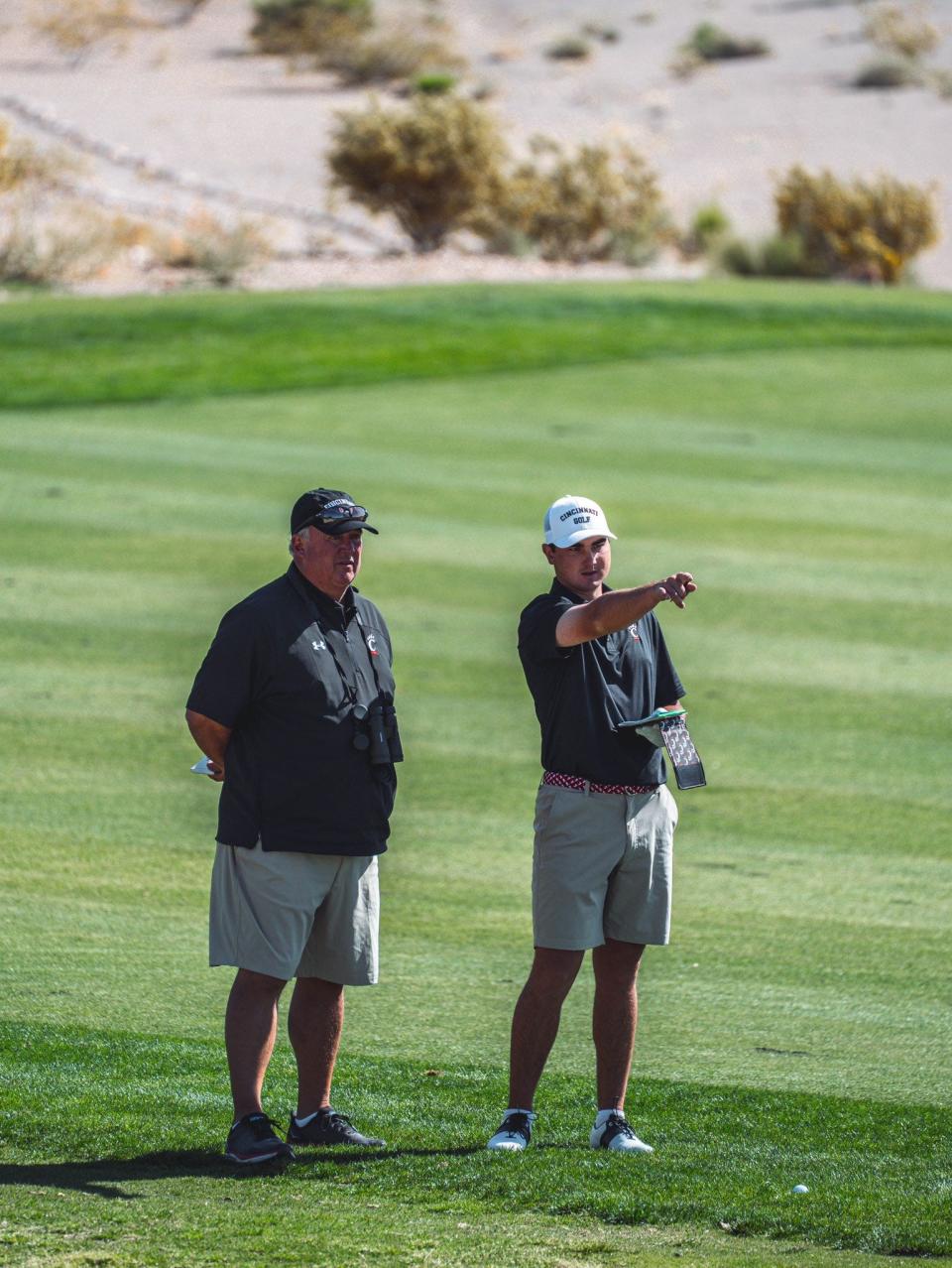 UC coach Doug Martin helps Ty Gingerich line up a shot. Gingerich is playing in an NCAA regional for the Bearcats for a second straight year.