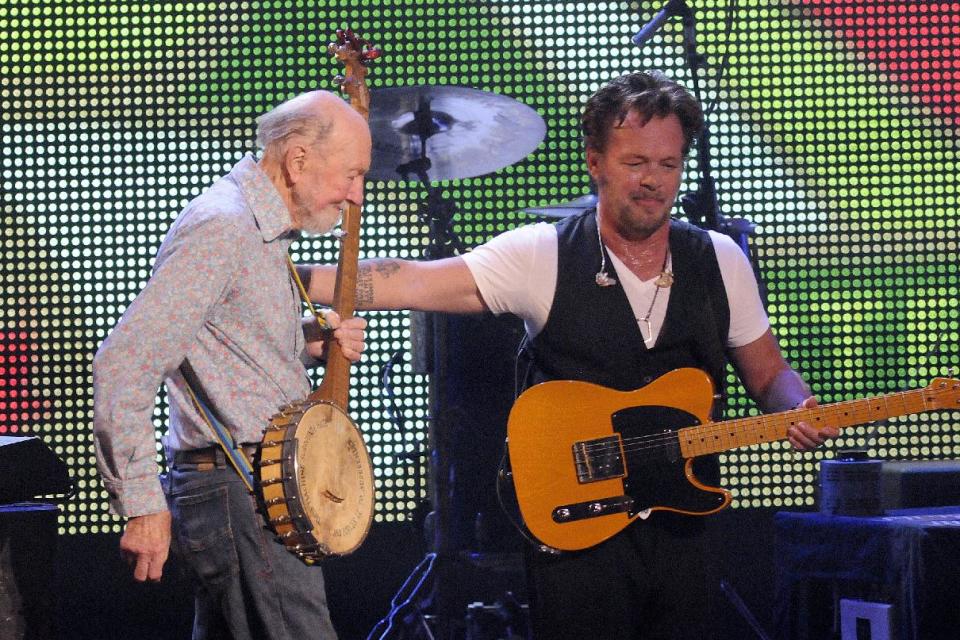 File-This Sept. 21, 2013, file photo shows Pete Seeger, left, being welcomed on stage by John Mellencamp during the Farm Aid 2013 concert at Saratoga Performing Arts Center in Saratoga Springs, N.Y. The American troubadour, folk singer and activist Seeger died Monday Jan. 27, 2014, at age 94. (AP Photo/Hans Pennink, File)