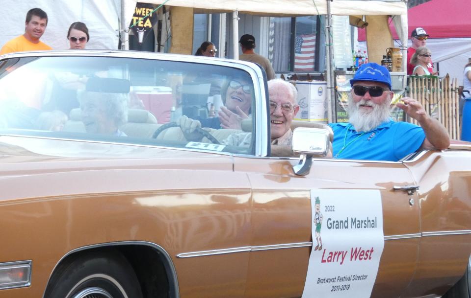 Parade Grand Marshal Larry West waves to the crowd during Thursday's parade at the 2022 Bucyrus Bratwurst Festival.