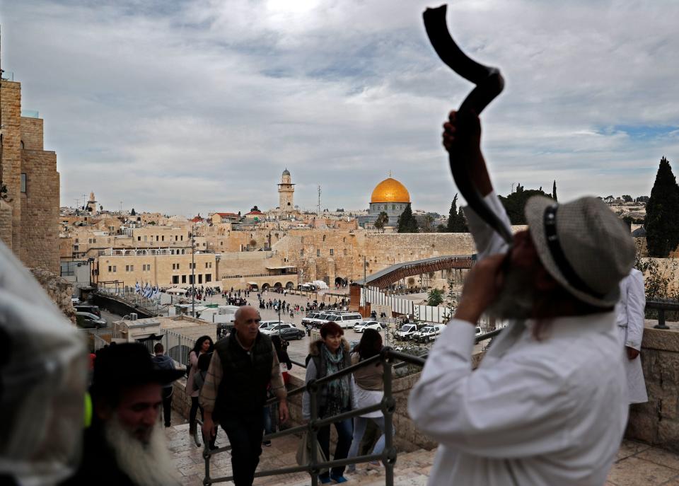 <p>A general view shows a Jewish man blowing a Shofar near the Western Wall (R) and the Dome of the Rock (C) in the Al-Aqsa mosque compound in the Old City of Jerusalem on Dec. 5, 2017. (Photo: Thomas Coex/AFP/Getty Images) </p>