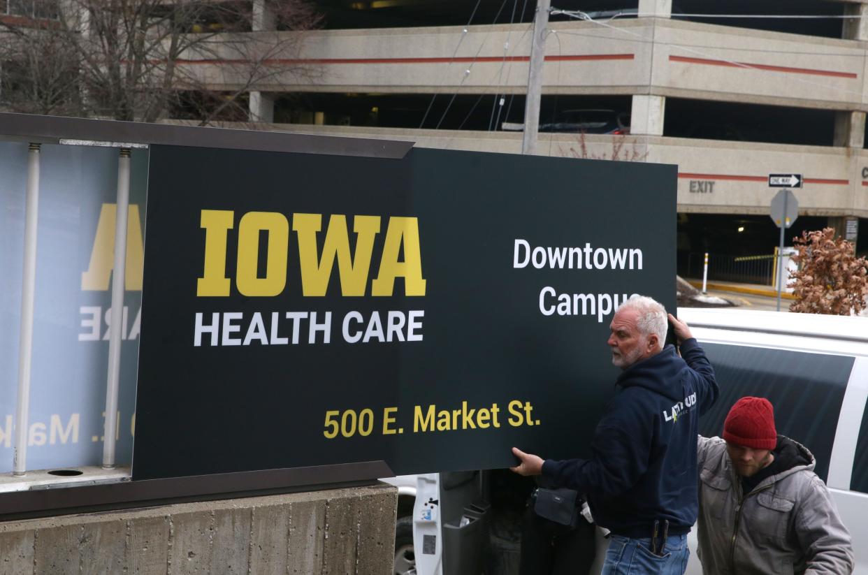 Latitude Signage & Design workers insert an Iowa Health Care downtown campus sign outside the former Mercy Iowa City hospital Wednesday, Jan. 31, 2024 in Iowa City, Iowa.