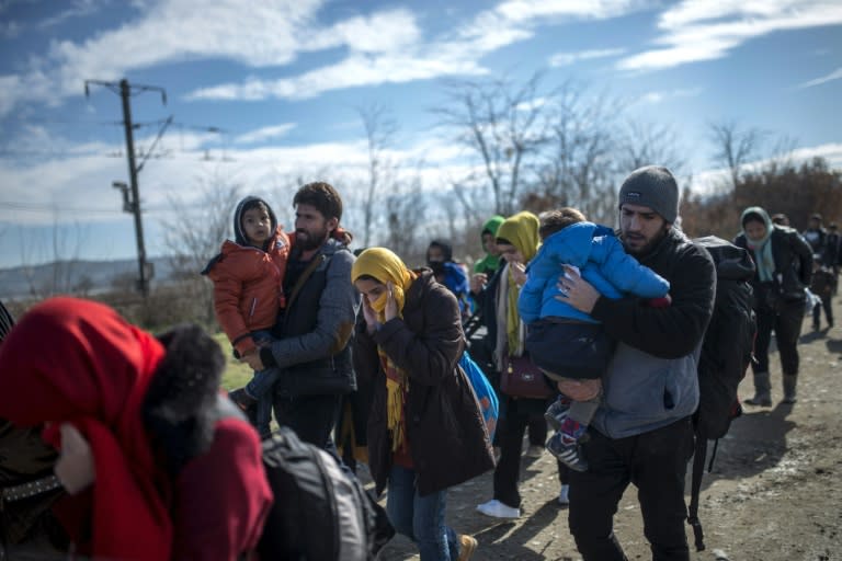 Migrants and refugees cross the Greek-Macedonian border near the town of Gevgelija, on February 14, 2016