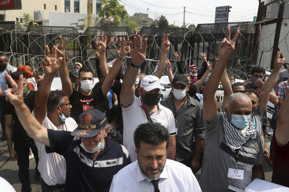 FILE - This Wednesday, July 29, 2020 file photo, dozens of Palestinians flash the victory sign as they protest against their permanent settlement in Lebanon and demanding immigration, near the U.S. embassy in Aukar, northeast of Beirut, Lebanon. The financial crisis that the U.N. agency for Palestinian refugees is experiencing could lead to ceasing some of its activities in what would raise risks of instability in this volatile region, the head of the agency said Wednesday, Sept. 16. (AP Photo/Bilal Hussein, File)