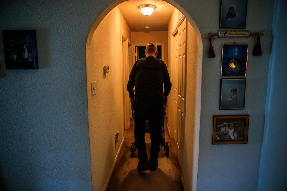 Fred Norris walks back to his bedroom Tuesday, Feb. 22, 2022, inside his home on Indianapolis' east side. Norris uses a walker to get around these days. An infection in his feet after partial foot amputations has caused him extra pain lately. He, like many Vietnam veterans, have suffered the side effects of Agent Orange.