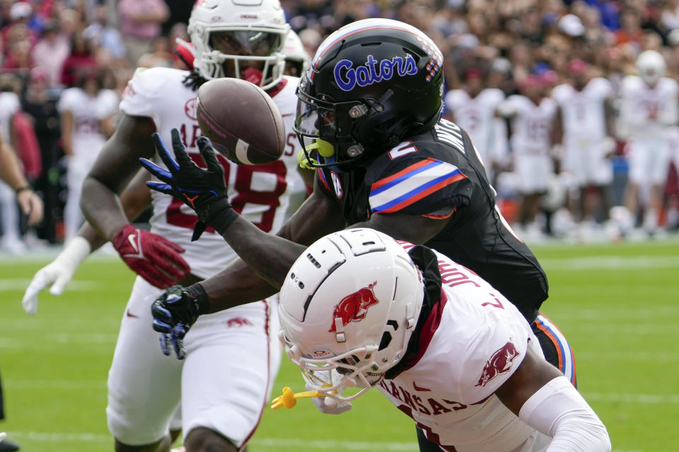 Florida running back Montrell Johnson Jr. (2) can't hang on to a pass as he is hit by Arkansas defensive back Lorando Johnson, right, during the first half of an NCAA college football game, Saturday, Nov. 4, 2023, in Gainesville, Fla. (AP Photo/John Raoux)