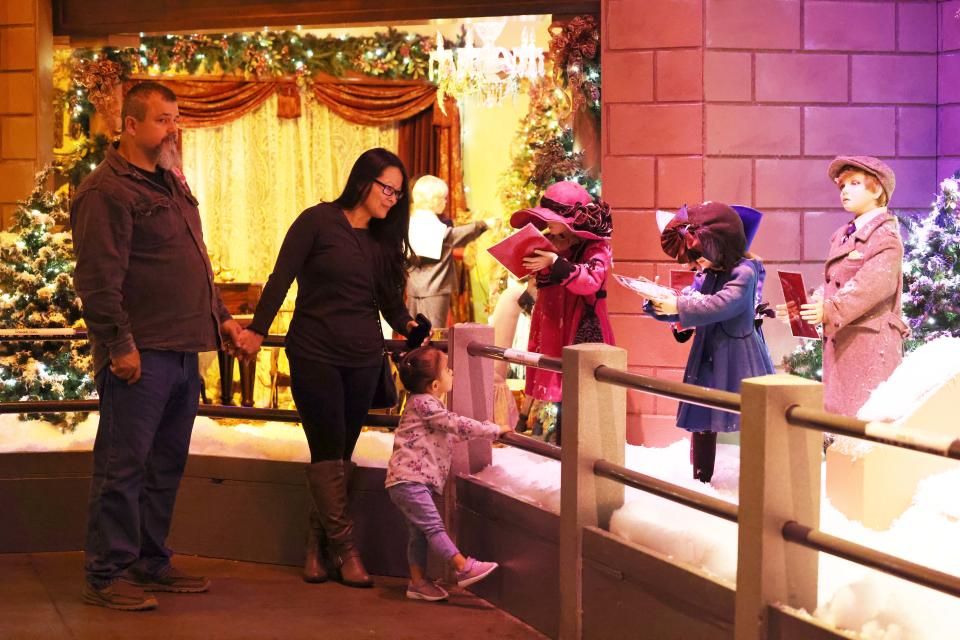 Tim Brain, Lan Baker, and Alita Mae, 2, of Hanson, at the "Enchanted Village" at  Jordan's Furniture in Avon on Saturday, Nov. 13, 2021.