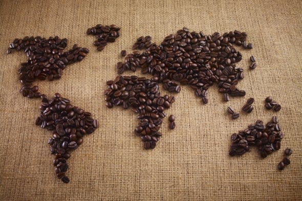 Coffee beans forming world map on burlap