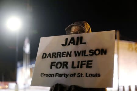 A demonstrator protests over the shooting death of Michael Brown in front of the Ferguson Police Department in Ferguson, Missouri, November 17, 2014. REUTERS/Jim Young
