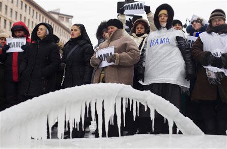 People sing religious songs at the barricades of an anti-government protesters camp near in Kiev, January 28, 2014. REUTERS/Thomas Peter