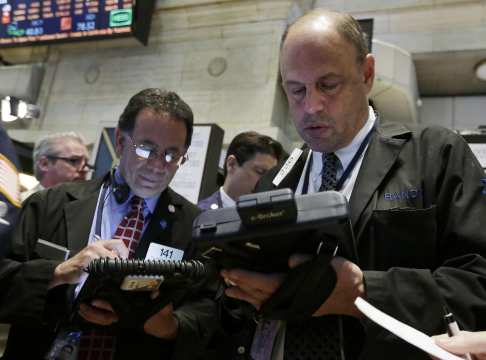 Randy Beller, right, works with fellow traders on the floor of the New York Stock Exchange Thursday, April 24, 2014. Mixed earnings from a large number of U.S. companies left the stock market without direction early Thursday, despite positive results from a handful of names including Apple and Caterpillar. (AP Photo/Richard Drew)