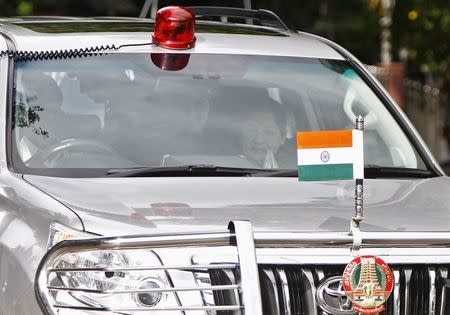 J. Jayalalithaa (R), chief minister of India's Tamil Nadu state and chief of the AIADMK party, gestures to her supporters (not pictured) after leaving her residence for the airport, in Chennai September 27, 2014. REUTERS/Babu