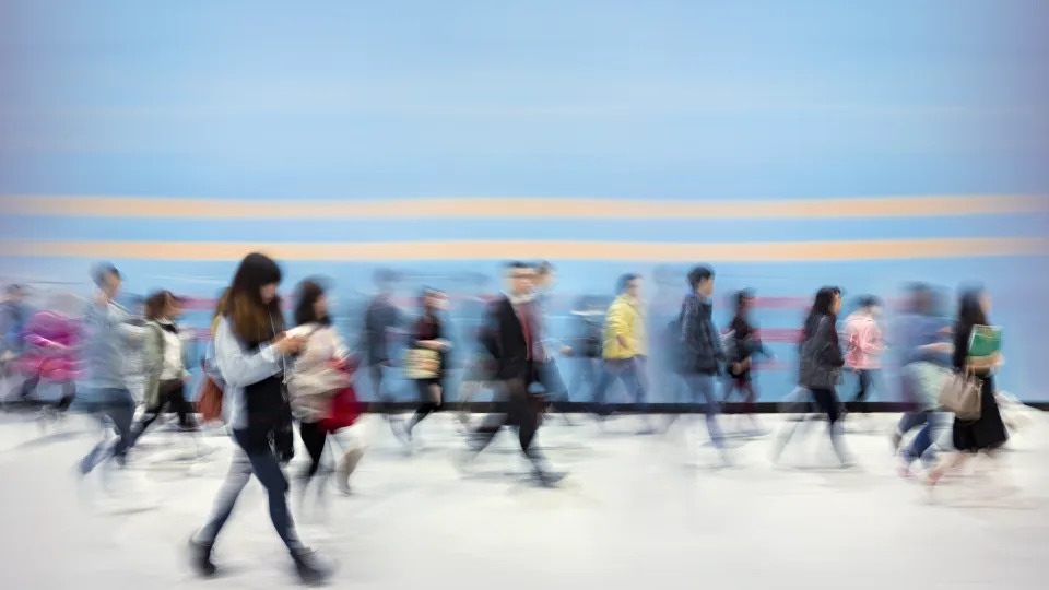 blurry photo of people walking on white ground against blue background with two white stripes in hong kong, blurry or double vision