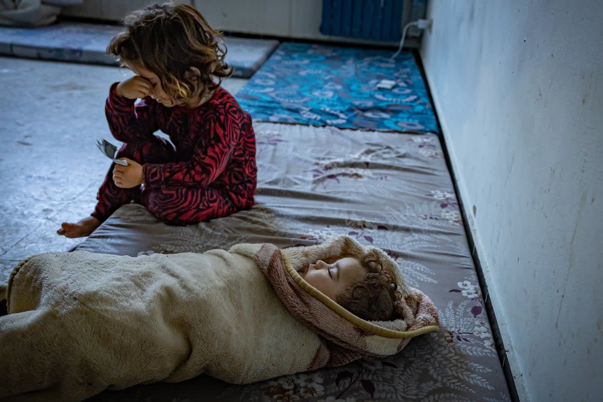Asmaa’s five-month-old baby swaddled in a blanket, with another of her children at a school in Tyre. The family is among those who have had to flee the clashes at the Lebanon-Israeli border (Bel Trew/The Independent)