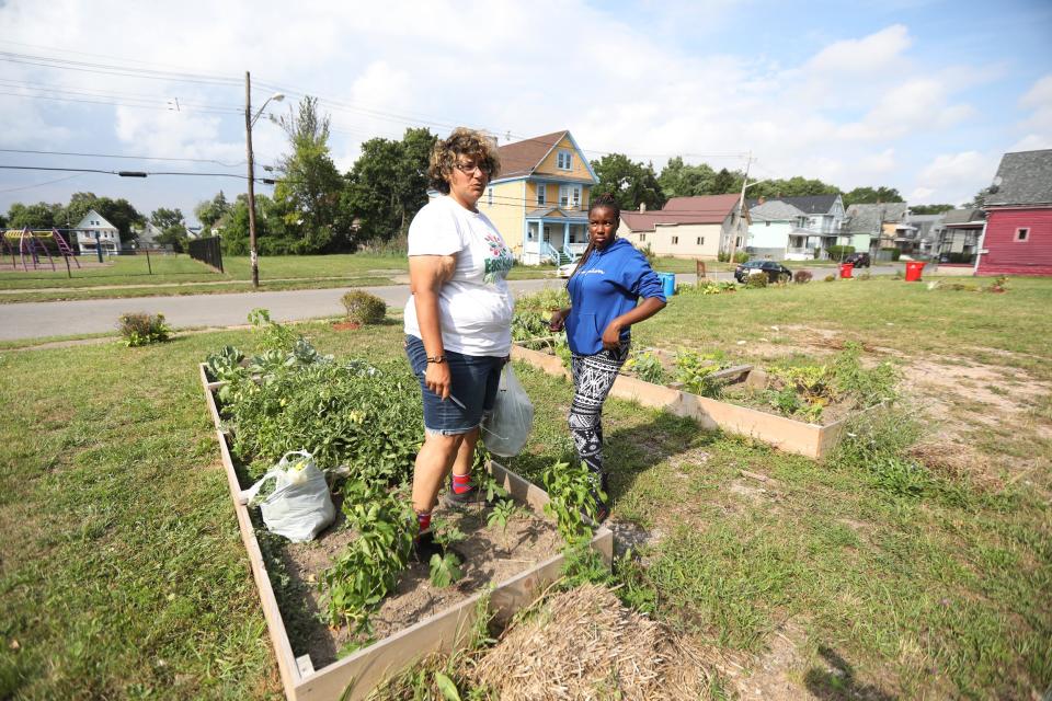 Samantha White, vice president of the Box Avenue Block Club, gets help from Juanita Hunter with the group’s Good Neighbors Garden located on Box Avenue in Buffalo on Thursday, July 28, 2022.