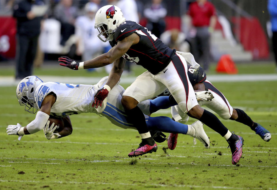 <p>Detroit Lions running back Theo Riddick is hit by Arizona Cardinals free safety Antoine Bethea, rear, and Arizona Cardinals cornerback Quinten Rollins, center, during the first half of NFL football game, Sunday, Dec. 9, 2018, in Glendale, Ariz. (AP Photo/Ross D. Franklin) </p>