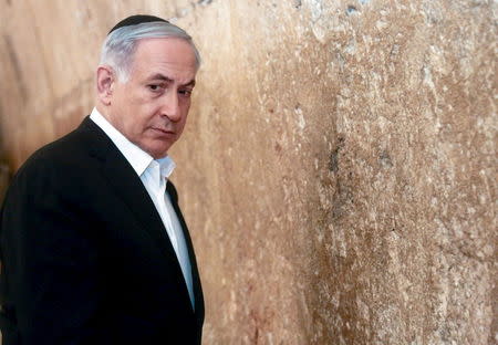 Israel's Prime Minister Benjamin Netanyahu stands next to the Western Wall, Judaism's holiest prayer site, during a visit in Jerusalem's Old City in this February 28, 2015 file photo. REUTERS/Marc Sellem/Pool/Files