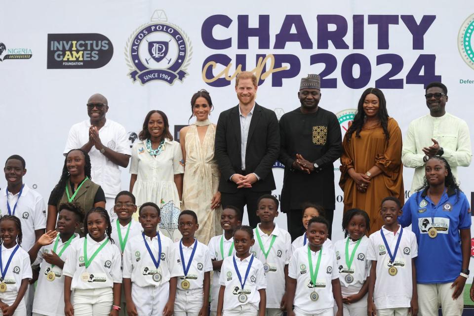 lagos polo club president bode makanjuola l, his wife moyo makanjuola 2ndl, britains meghan 3rdl, duchess of sussex, britains prince harry 4thl, duke of sussex, nigeria chief of defense staff christopher musa 3ndr, his wife lilian musa 2ndr and regional head of equity research for west africa at standard bank group, muyiwa oni r pose for a photo with children after a charity polo game at the ikoyi polo club in lagos on may 12, 2024 as they visit nigeria as part of celebrations of invictus games anniversary photo by kola sulaimon afp photo by kola sulaimonafp via getty images