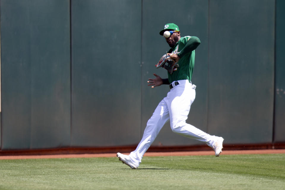 Oakland Athletics center fielder Starling Marte (2) can't cleanly field Texas Rangers' Nathaniel Lowe's RBI double during the first inning of a baseball game, Sunday, Aug. 8, 2021, in Oakland, Calif. Texas Rangers' Adolis García scored from second base on the hit. (AP Photo/D. Ross Cameron)