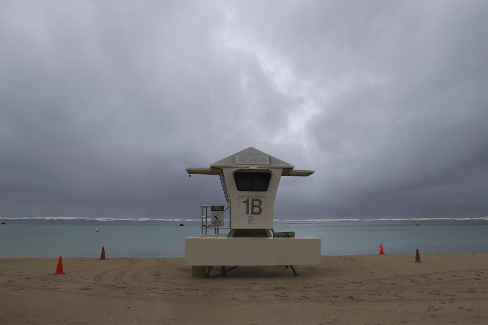 Dark clouds hang over a lifeguard tower on Ala Moana Beach Park, Monday, Dec. 6, 2021, in Honolulu. (AP Photo/Marco Garcia)