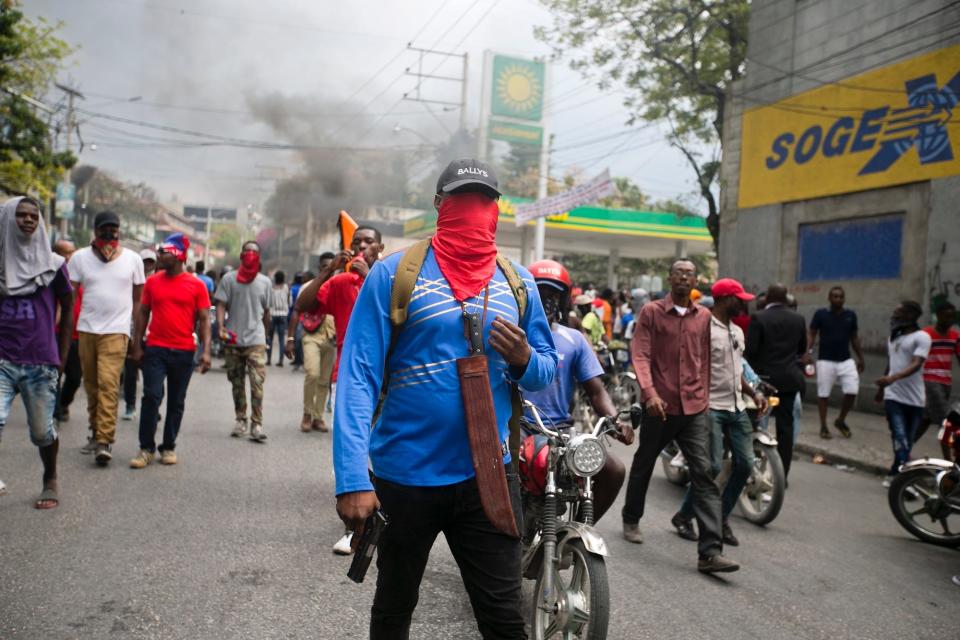 Armed off-duty police officers protest over police pay and working conditions, in Port-au-Prince, Haiti, Sunday, Feb. 23, 2020.