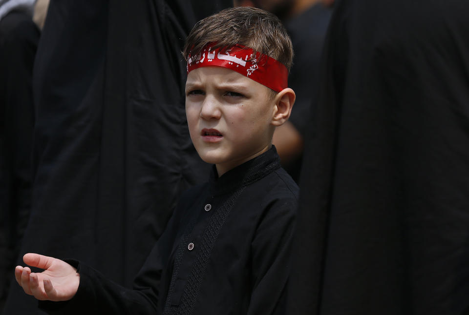 A Shiite Muslim boy beats his chest with others in a symbolic ritual during a Muharram procession, in Islamabad, Pakistan, Monday, Aug. 8, 2022. Muharram, the first month of the Islamic calendar, is a month of mourning for Shiites in remembrance of the death of Hussein, the grandson of the Prophet Muhammad, at the Battle of Karbala in present-day Iraq in the 7th century. (AP Photo/Anjum Naveed)