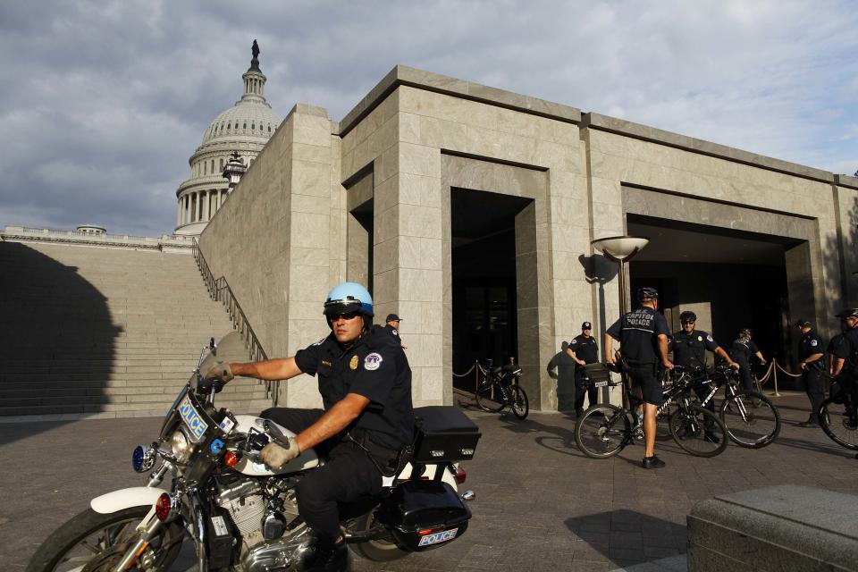 U.S. Capitol Police return to patrol after a brief meeting to discuss how to handle tourists turned away from the shuttered visitor's center at the U.S. Capitol in Washington, October 1, 2013. The U.S. government began a partial shutdown for the first time in 17 years, potentially putting up to 1 million workers on unpaid leave, closing national parks and stalling medical research projects. REUTERS/Jonathan Ernst (UNITED STATES - Tags: POLITICS BUSINESS)