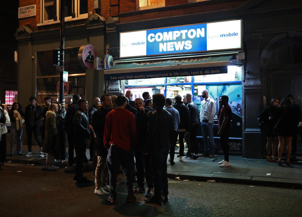 People queuing outside Compton News convenience store in Soho, London, after pubs and restaurants were subject to a 10pm curfew to combat the rise in coronavirus cases in England.