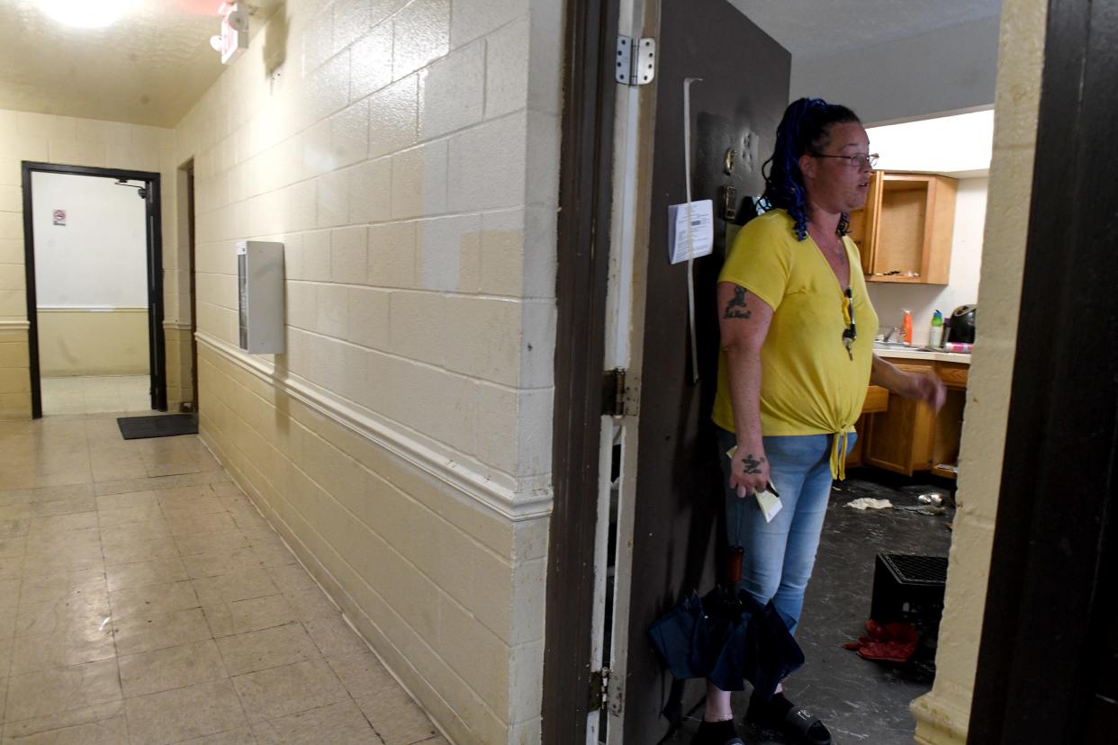 Annah Williams, a tenant at Victory Square Apartments in Canton, stands in the doorway of an apartment that has been abandoned since February but still hasn't been cleaned out and is attracting rodents and other pests.