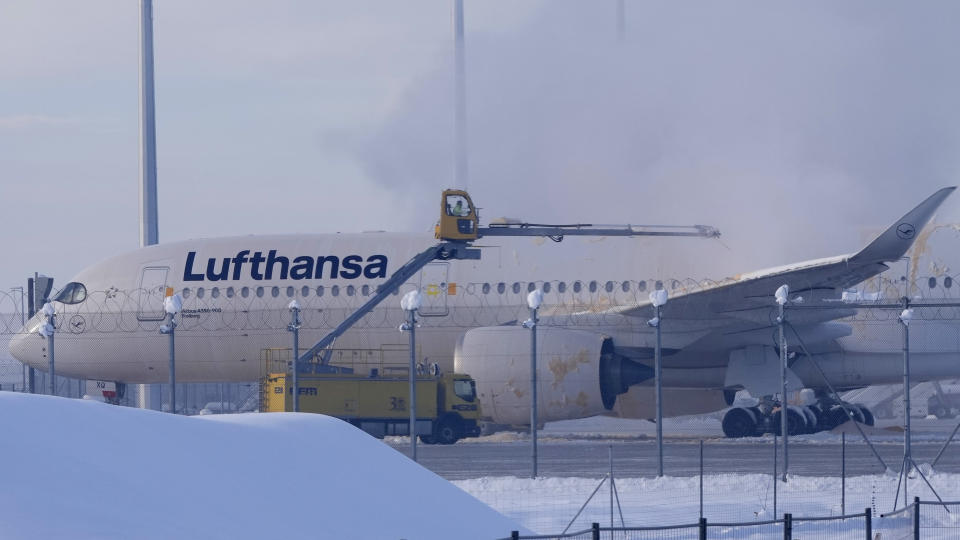 A Lufthansa aircraft is de-iced at the airport in Munich, Germany, Tuesday, Dec. 5, 2023.Munich Airport temporarily suspended flight operations on Tuesday morning due to freezing rain as cold weather continued in the region. (AP Photo/Matthias Schrader)