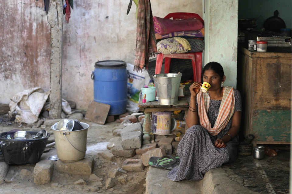Penupothula Ratnam, a daily wage shrimp worker, sips tea at her residence in Bhogapuram village, Kakinada district, Andhra Pradesh, India, Wednesday, Feb. 14, 2024. Ratnam said she suffers back pain all the time from the arduous work, which pays about $3 a day. (AP Photo/Mahesh Kumar A.)