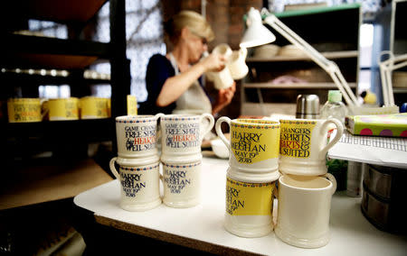 A worker adds transfers to mugs commemorating the wedding of Britain's Prince Harry and Meghan Markle at the Emma Bridgewater Factory, in Hanley, Stoke-on-Trent, Britain March 28, 2018. REUTERS/Carl Recine