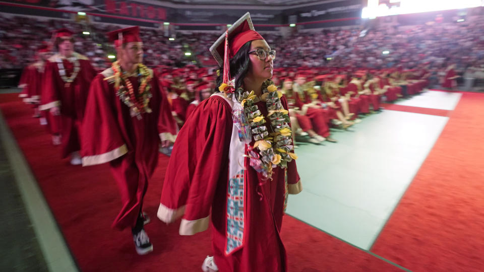 FILE - Amryn Tom graduates from Cedar City High School on Wednesday, May 25, 2022, in Cedar City, Utah. Tom is wearing an eagle feather given to her by her mother and a cap that a family friend beaded. (AP Photo/Rick Bowmer, File)