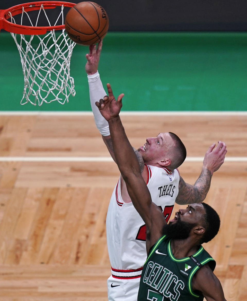 Chicago Bulls center Daniel Theis, left, tries to tip in a rebound against Boston Celtics guard Jaylen Brown, right, during the first half of an NBA basketball game, Monday, April 19, 2021, in Boston. (AP Photo/Charles Krupa)