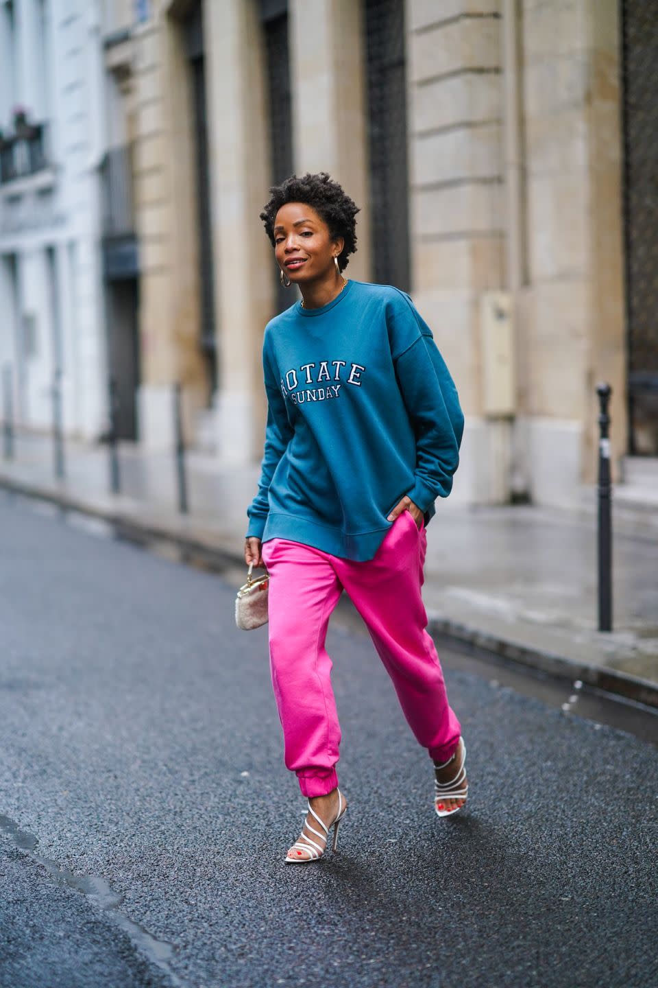 paris, france january 23 ellie delphine aka slipintostyle wears earrings, a blue oversized wool pullover from rotate, neon pink jogger sport pants from rotate, a small white fluffy fendi bag, white pointy high heeled lace up shoes from gianvitto rossi, on january 23, 2021 in paris, france photo by edward berthelotgetty images