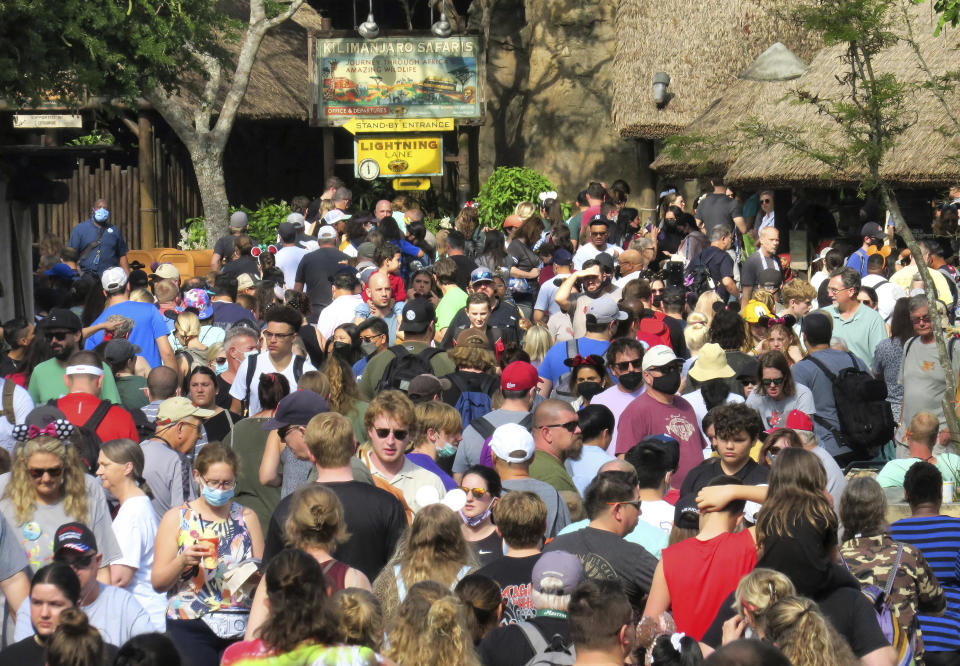 Guests crowd the Harambe village area of Disney's Animal Kingdom, Thursday, Dec. 30, 2021, as Walt Disney World's four Florida theme parks are filled to near-capacity for the New Year's Eve holiday in Lake Buena Vista, Fla. As of Thursday afternoon, Animal Kingdom was the only park showing available reservations for ticket holders, Disney resort guests and annual pass-holders for New Year's Eve, Jan. 31. (Joe Burbank/Orlando Sentinel via AP)