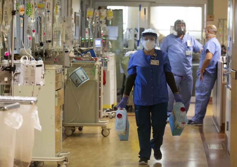 FULLERTON, CA - DECEMBER 25: Maria Padilla, with Environmental Services is cleaning rooms with a covid positive patient inside the ICU at Providence St. Jude Medical Center Christmas Day on Friday, Dec. 25, 2020 in Fullerton, CA. (Francine Orr / Los Angeles Times)