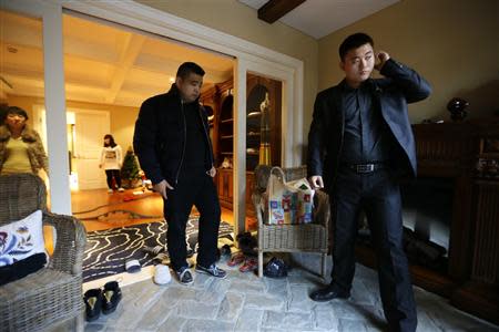 Bodyguard Han, who was hired from Tianjiao Special Guard/Security Consultant, checks his earphone as his employer Zhang prepares to leave home on the outskirts of Beijing December 15, 2013. REUTERS/Jason Lee