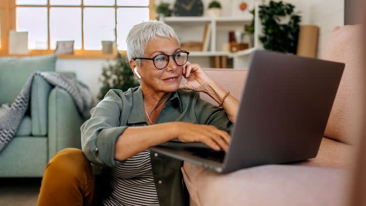 A woman looks at her retirement savings on her laptop. 