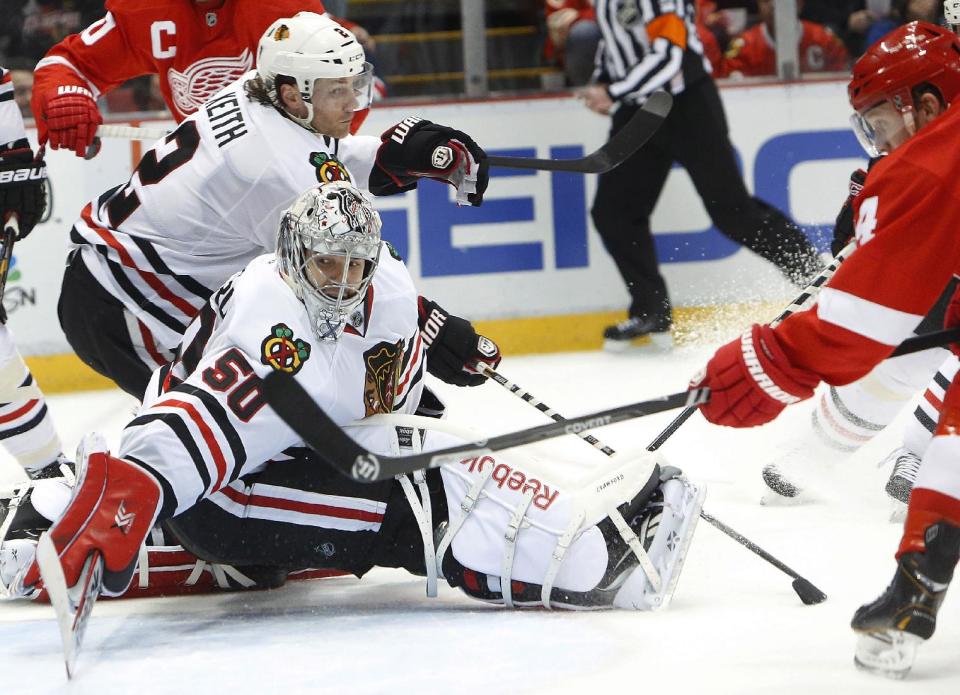 Detroit Red Wings center Gustav Nyquist, of Sweden, right, scores against Chicago Blackhawks goalie Corey Crawford (50) in the second period of an NHL hockey game Wednesday, Jan. 22, 2014, in Detroit. (AP Photo/Paul Sancya)
