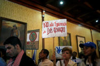 A government supporter holds a placard (C) that reads "No to the interference of Luis Almagro" during the news conference of Venezuela's Foreign Minister Delcy Rodriguez, in Caracas, Venezuela March 15, 2017. REUTERS/Marco Bello