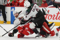 Arizona Coyotes center Liam O'Brien loses the puck and falls over Detroit Red Wings right wing Christian Fischer (36) during the second period of an NHL hockey game, Thursday, March 14, 2024, in Detroit. (AP Photo/Carlos Osorio)