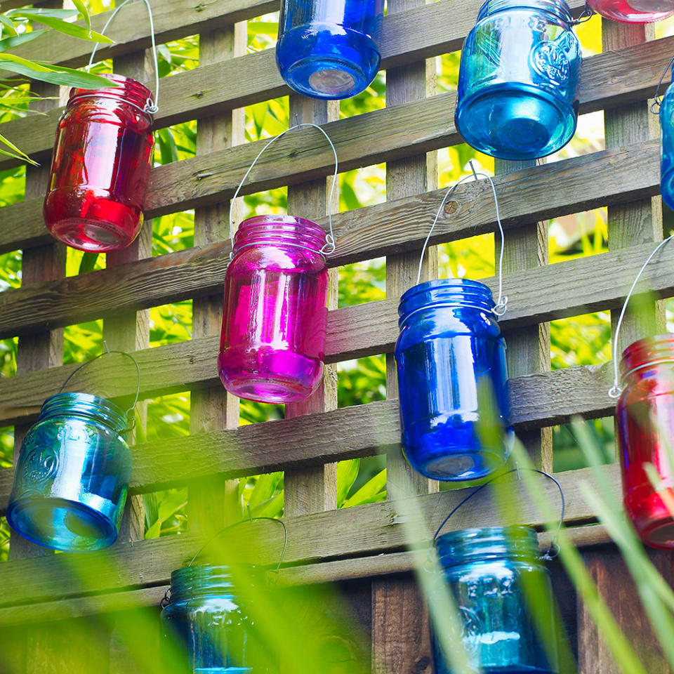 Decorate your garden fence with colourful tealight holders